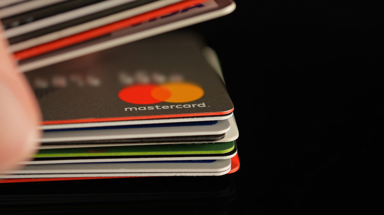 Many credit cards in a stack in someone's hand