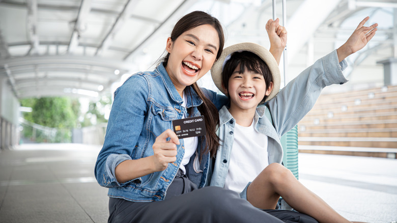 Mother and kid with credit card getting ready to fly