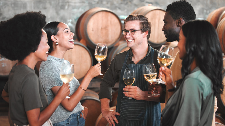 group of friends touring barrel cellar of winery