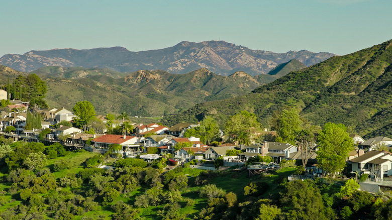 view of green mountains and houses under blue sky