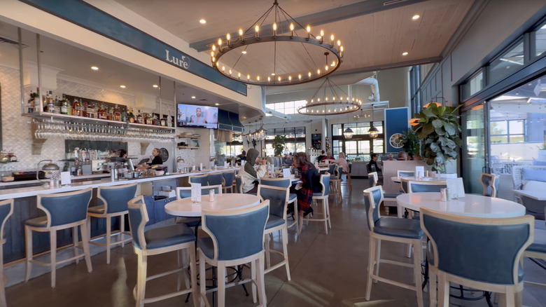 blue and white tables in restaurant with bar and lit chandelier