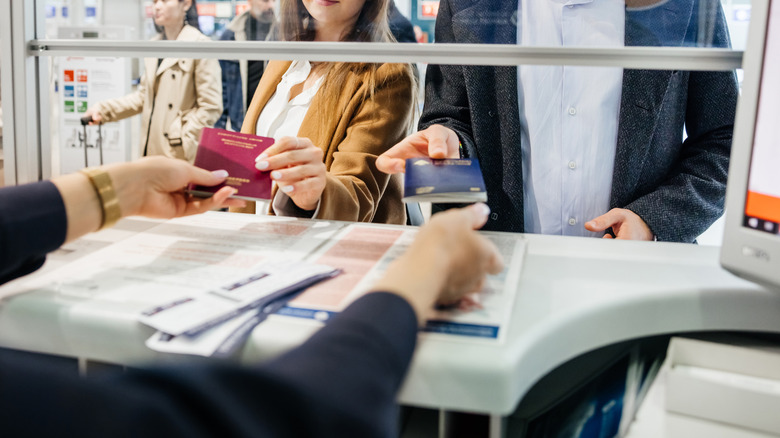 Couple handing passports to immigration
