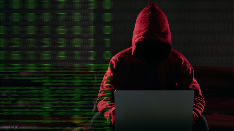 Hacker using laptop with numbers in the background