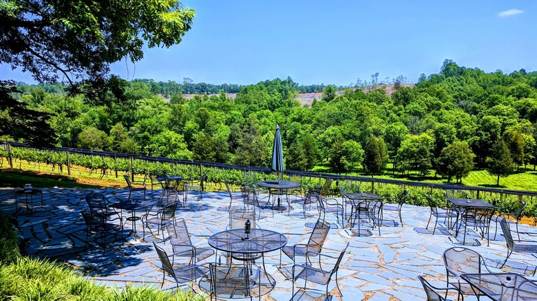 Flagstaff stone terrace with tables overlooking green trees and blue sky Zimmerman Vineyards