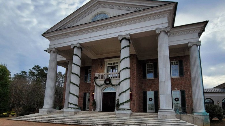 Linbrook Hall with white columns and Christmas wreath cloudy sky