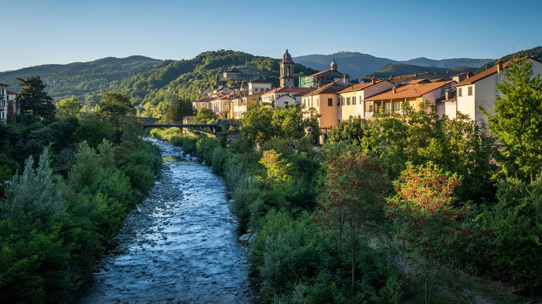 A river passing idyllic houses and greenery in Pontremoli, Italy
