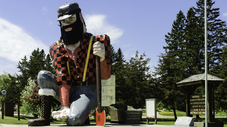 Giant lumberjack statue near trees