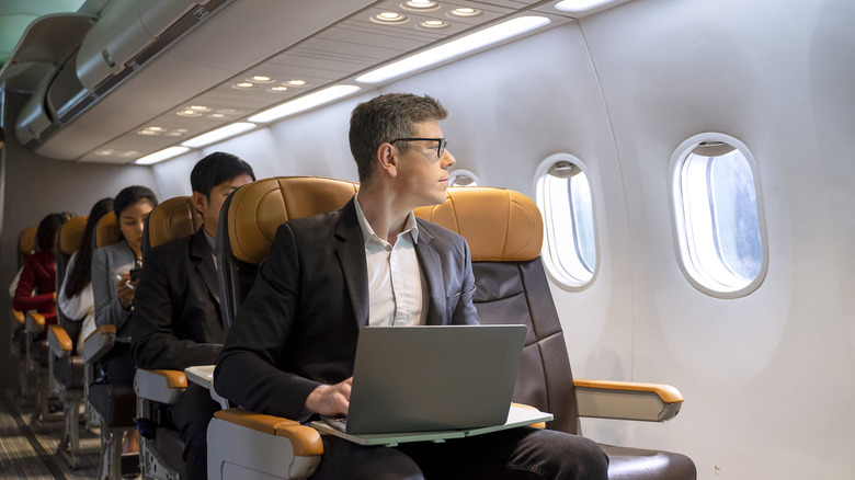 Passenger using a laptop on a plane