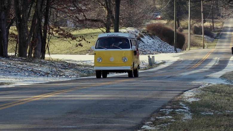 A yellow Volkswagen bus riding down Gravity Hill in Mooresville, Indiana