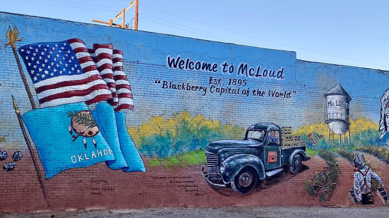 mural on brick wall showcasing flags and cars and people