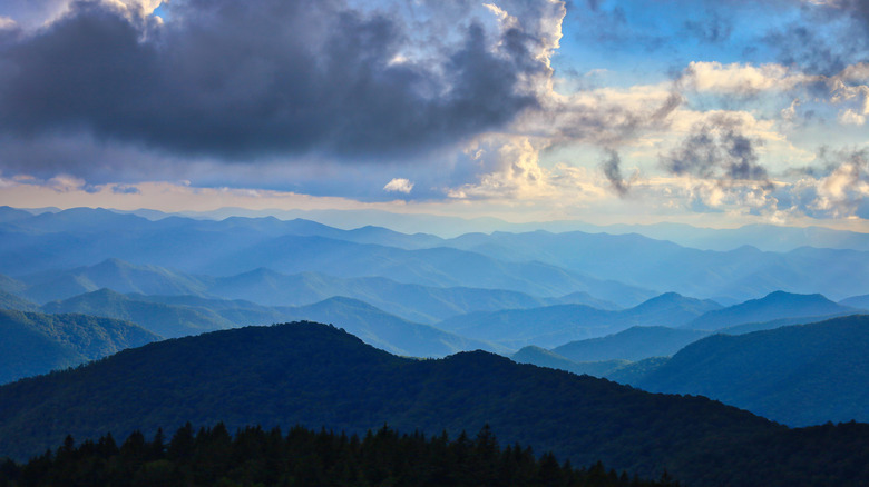 A beautiful landscape of the famous deep layers of the Blue Ridge Mountains under a cloudy blue sky near Ashville, North Carolina in the United States.