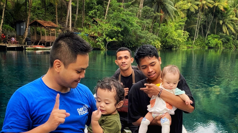 Men and their children out on a small boat on Lake Paisu Pok