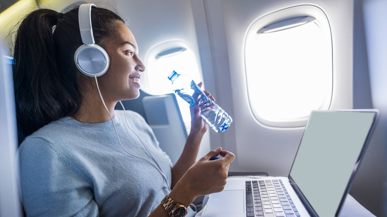 Woman drinking water on plane