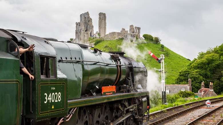 The historic Swanage Railway steam train pulling into Corfe Castle station in Dorset, England
