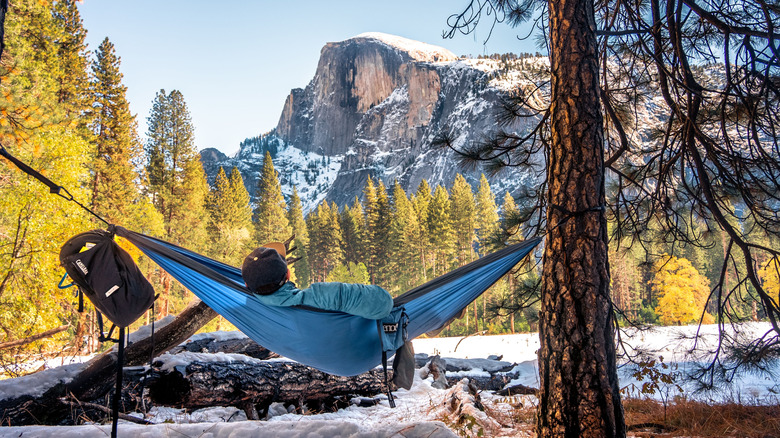 Person in a hammock overlooking snowy mountains in Yosemite National Park