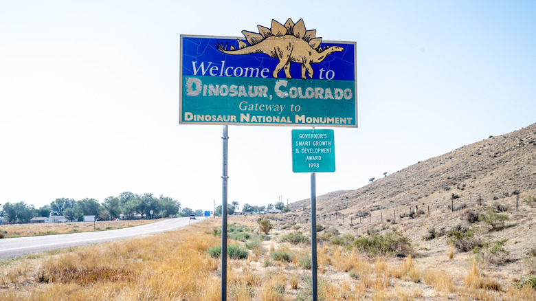 Road sign and marker for Dinosaur, Colorado