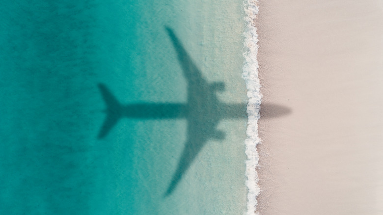 Shadow of an airplane flying over a beach