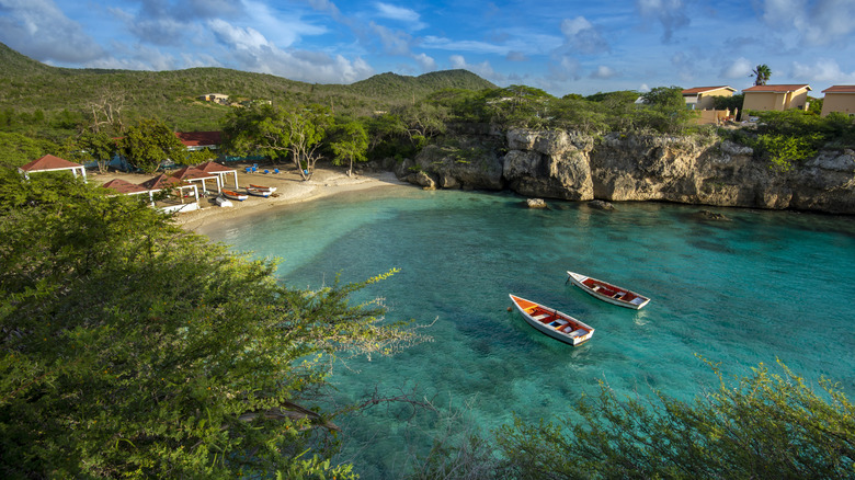 Two boats floating in water near beach resort, Curaçao