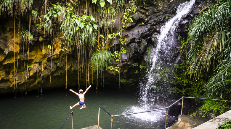 Child jumping into pool of waterfall