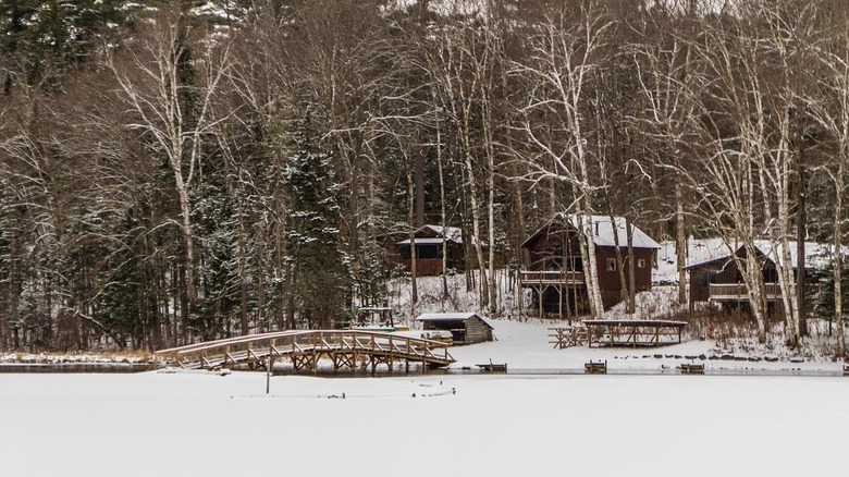 Snow-covered cabins and trees as seen from frozen Minerva Lake