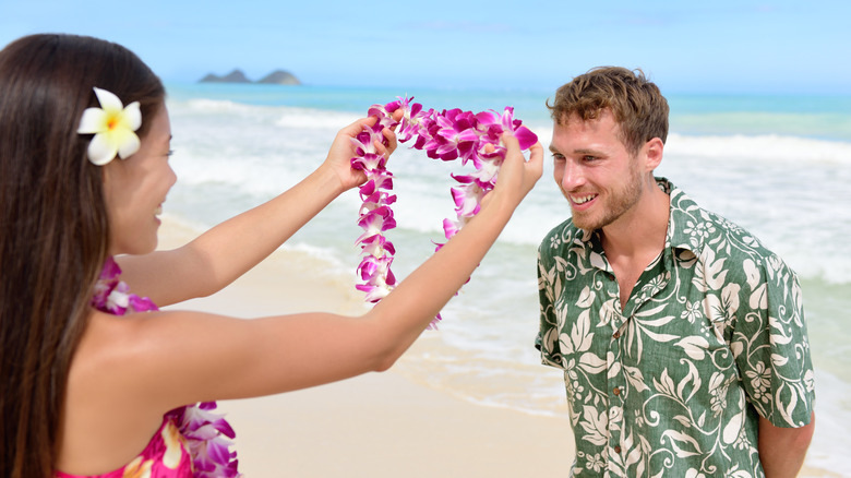 Woman gifting man a lei garland