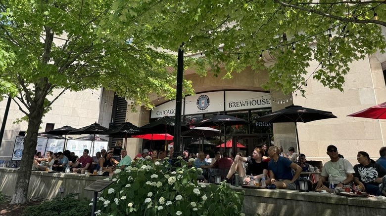 People sit at tables outside Chicago Brewhouse along the Riverwalk