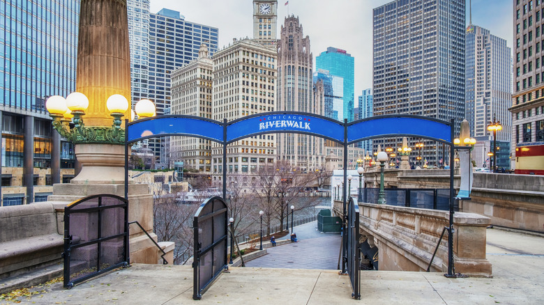 An entrance to the Chicago Riverwalk with skyscrapers in the background