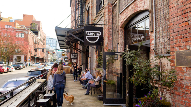 People enjoying coffee in front of a brick coffee shop