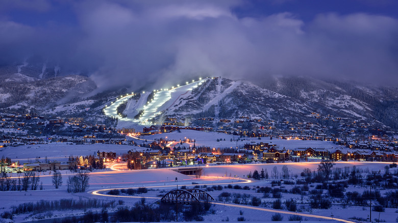 A distant view of Steamboat Ski Resort with several slopes lit up for night skiing