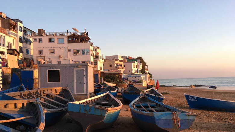 Sunset over boats and buildings on the beach in Taghazout