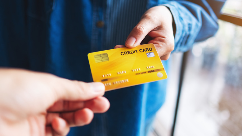 Someone passing a credit card to another person