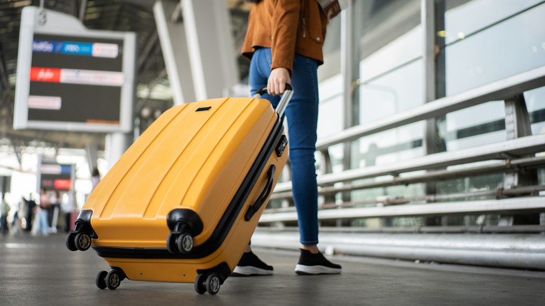 Woman rolling her suitcase in the airport