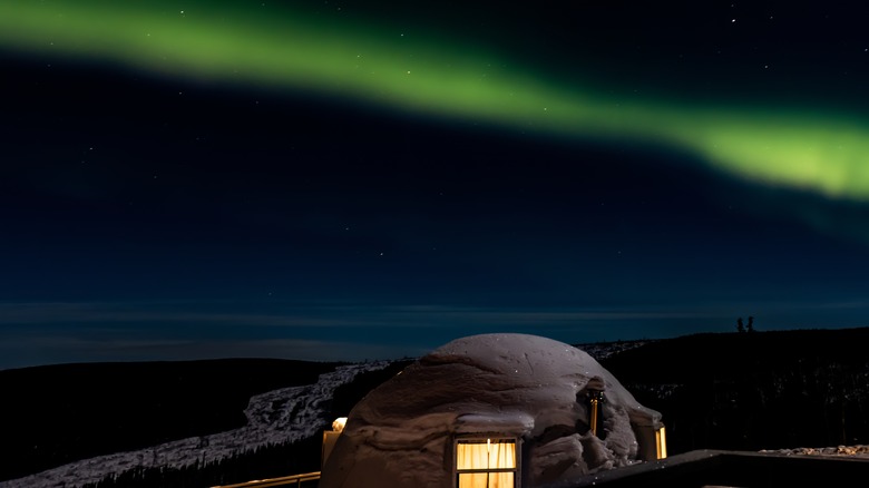 An igloo cabin under the Northern Lights