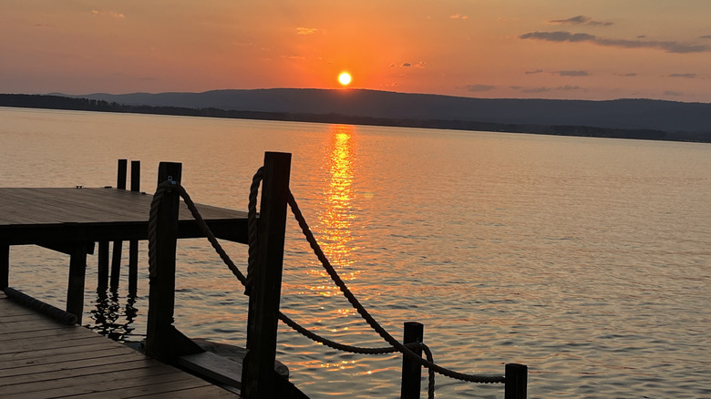A dock by water at sunrise