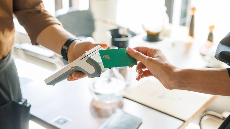 Customer tapping green contactless card