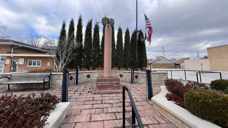 The nations first Vietnam Veterans Memorial beside the American flag on a cloudy day in downtown Wentzville, MO