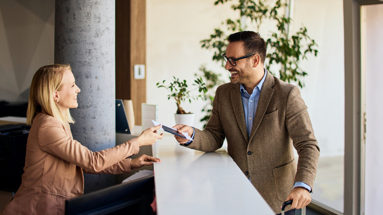 hotel clerk and guest interacting at front desk