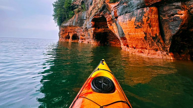 A kayak by a rocky bluff