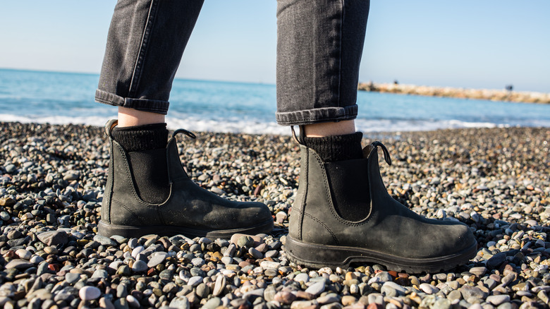 Close-up of black Blundstone Chelsea boots on a beach