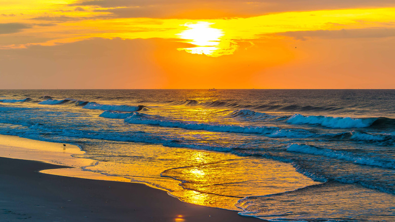 The sun over ocean waves at a beach on the East Coast