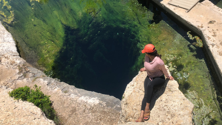 A girl looking down the watering hole in Jacob's Well