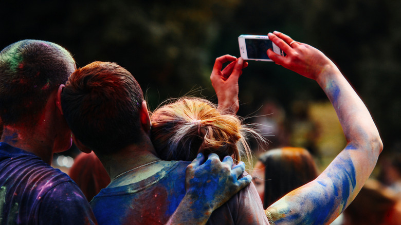 People taking selfies during India's Holi festival