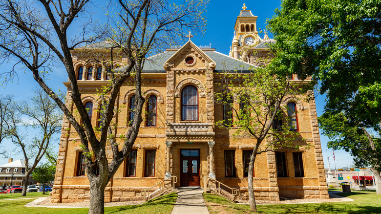 Tan facade of Llano County Courthouse sunny day