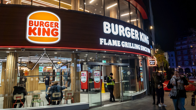 The storefront of a fancy Burger King at night