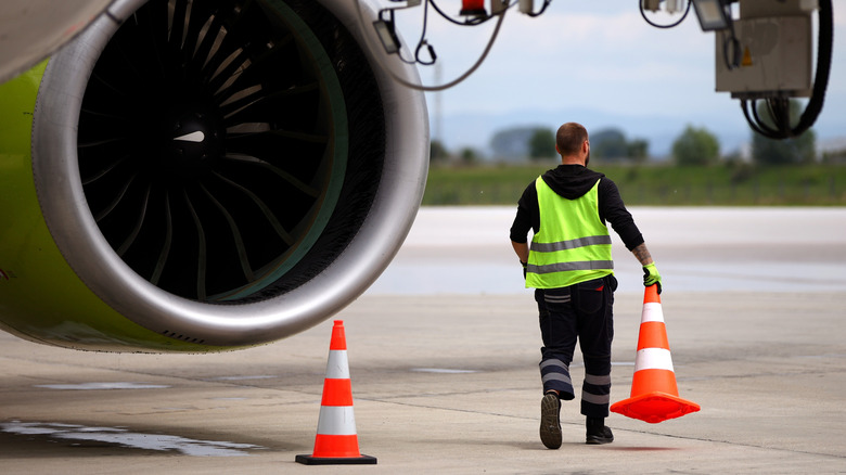 Airport worker moving cones
