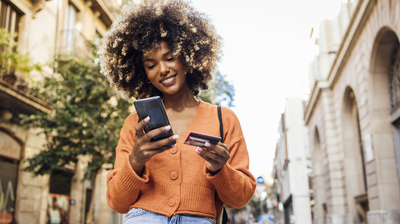 Woman holding her phone and card