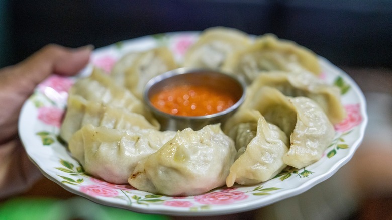 Nepali momo dumplings on a white plate with pink roses