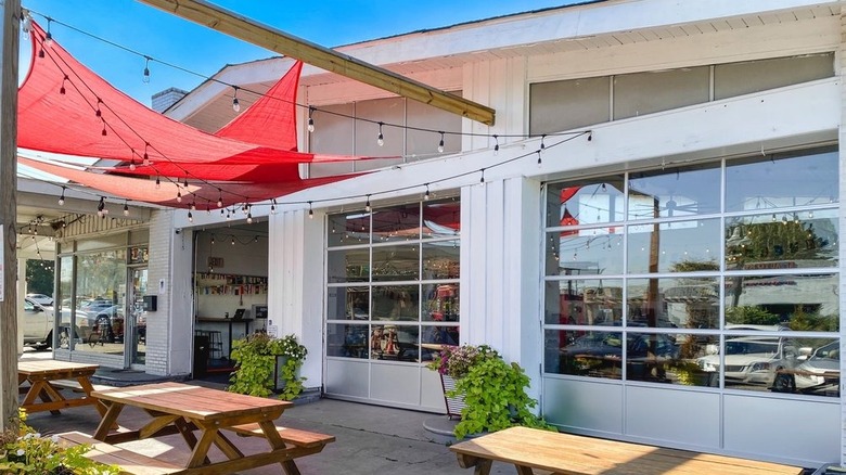 Refuge Coffee shop in Clarkston, Georgia with white garage doors and picnic tables