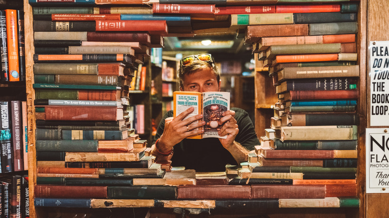 Man reading a book inside a book tunnel at The Last Bookstore, Los Angeles, California