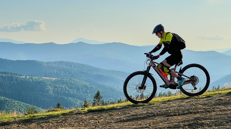 A man riding an E-bike with rolling hills in the background